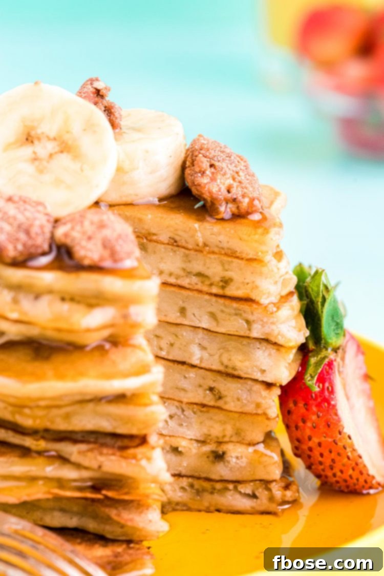 Close-up view of a stack of fluffy banana pancakes with a slice removed, revealing their tender interior.