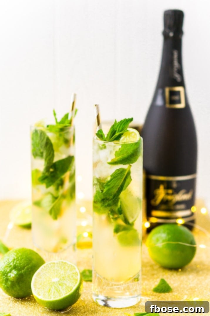 Close-up of a refreshing Champagne Mojito cocktail, garnished with fresh mint and lime slices.