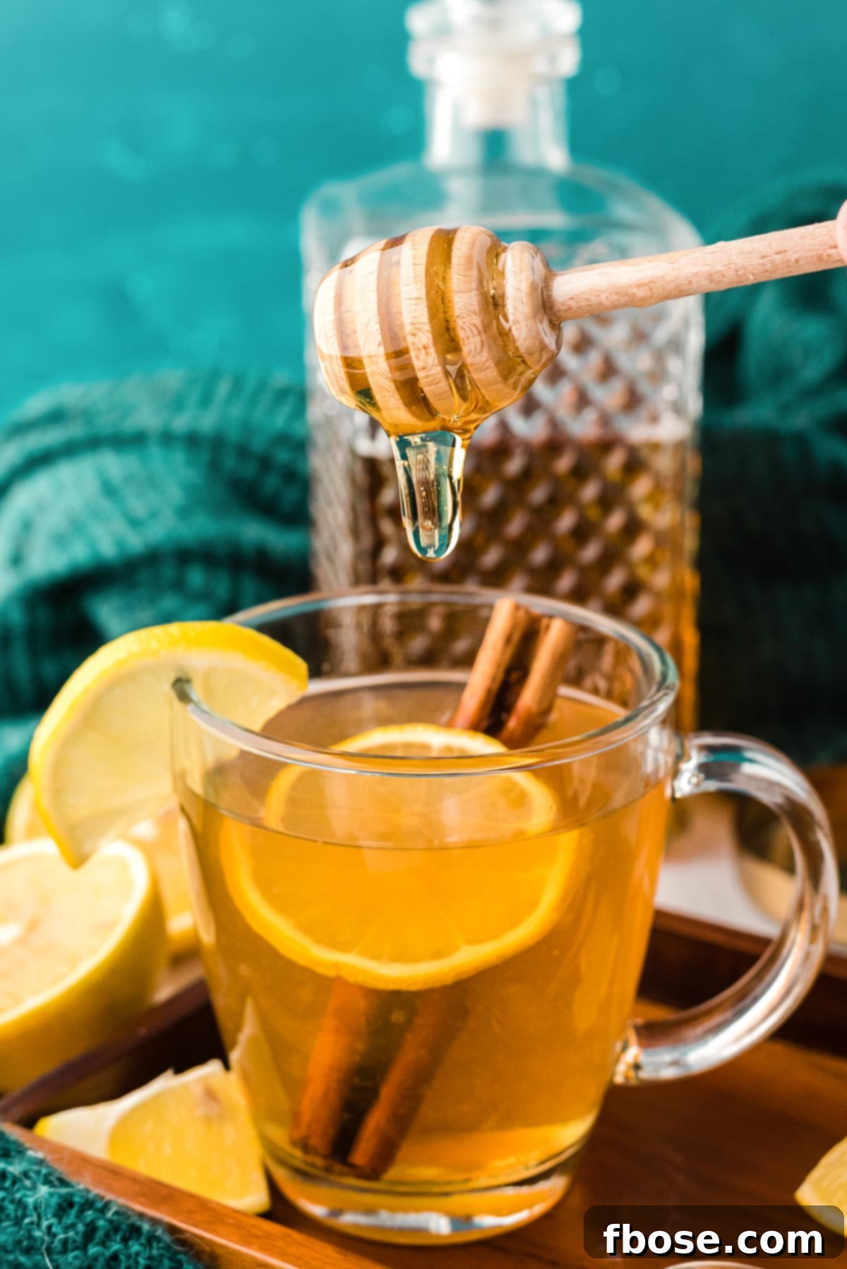 Honey being added to a mug of tea, creating a beautiful amber swirl.