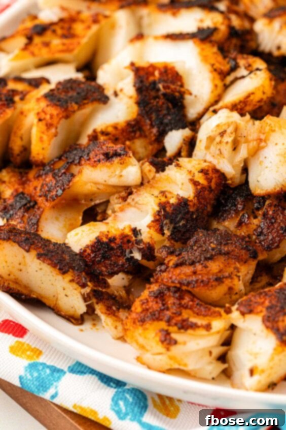 Close up of broken up blackened fish.