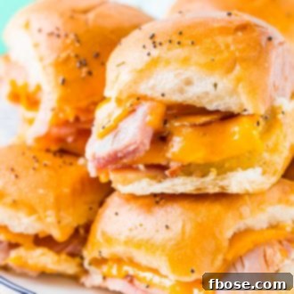 Perfectly baked Ham and Cheddar Sliders on Hawaiian Rolls with golden tops and melted cheese.