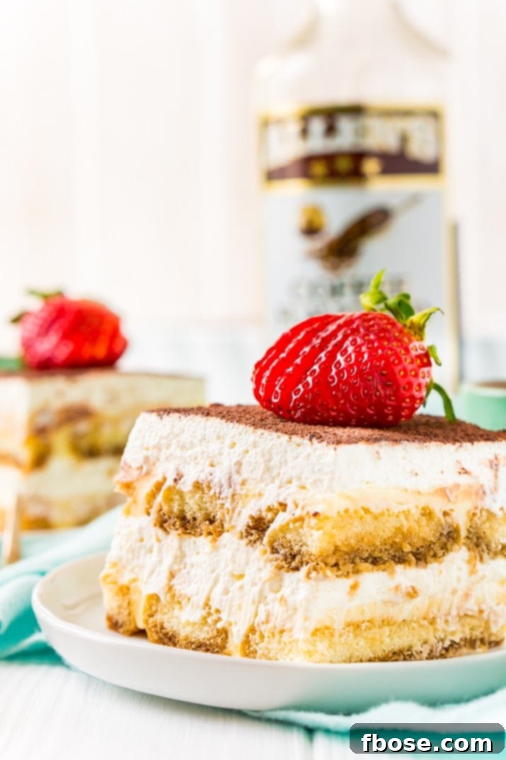 Tiramisu on Plate with Coffee Liqueur Bottle and Strawberry