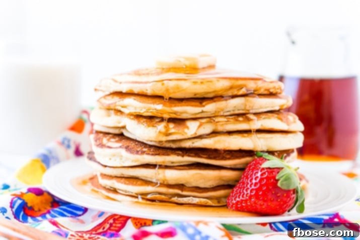 Buttermilk Pancakes served with fresh strawberries on a white plate