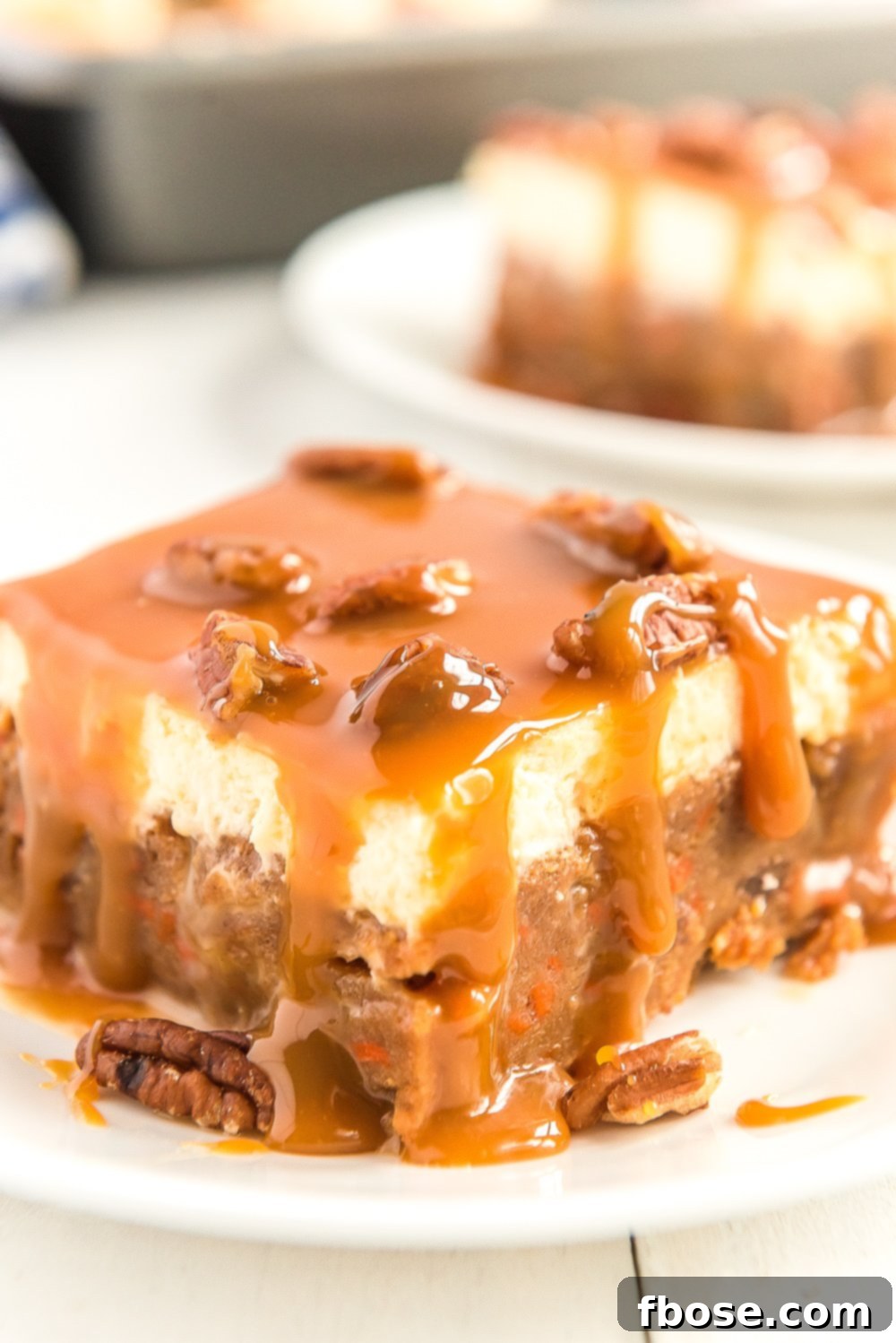Slice of Caramel Carrot Cake Poke Cake on a white plate.