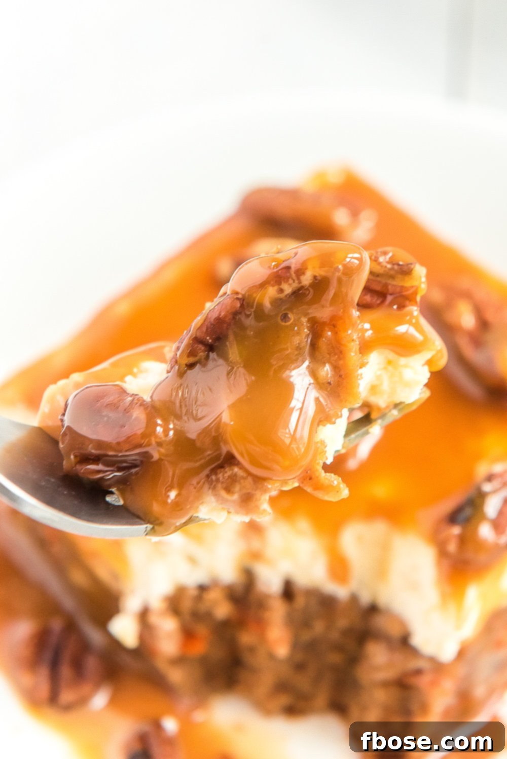 Fork with a bite of Caramel Carrot Cake Poke Cake on it. 