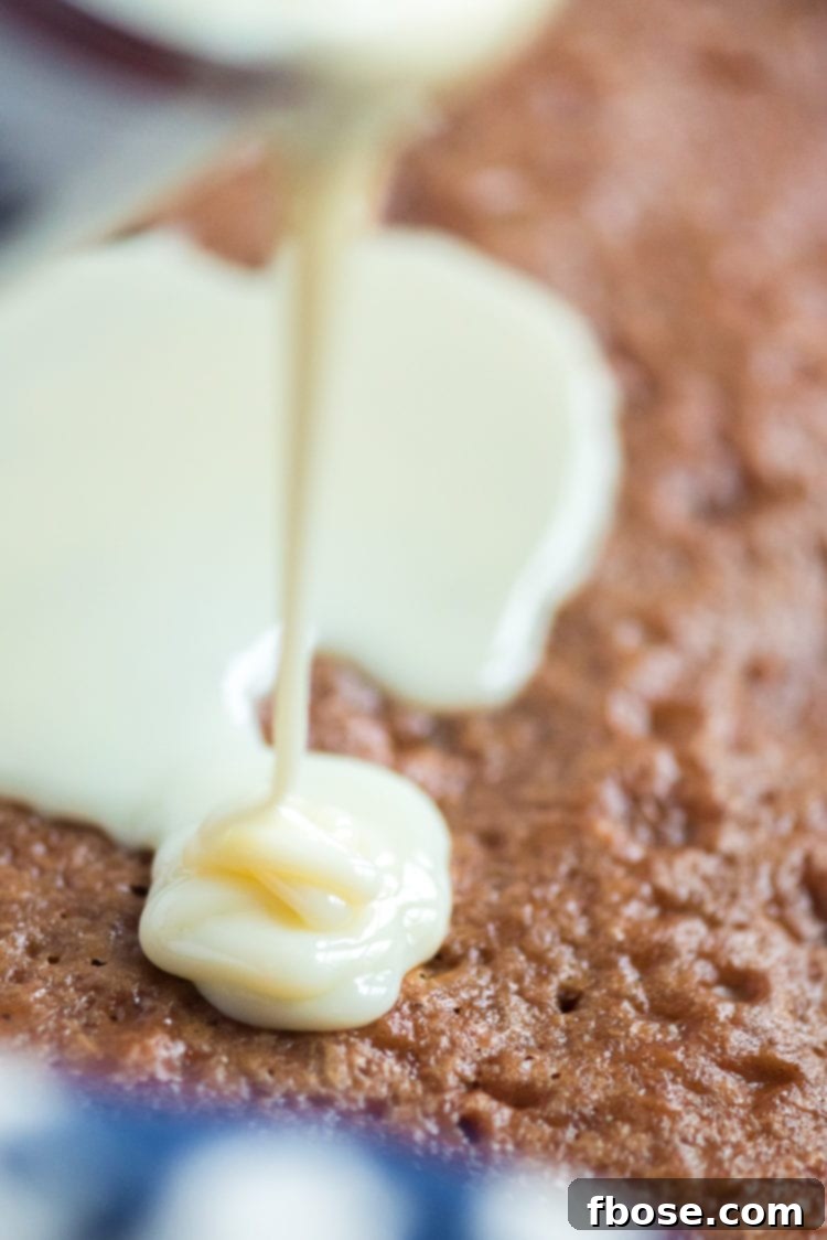 Pouring sweetened condensed milk over carrot cake.