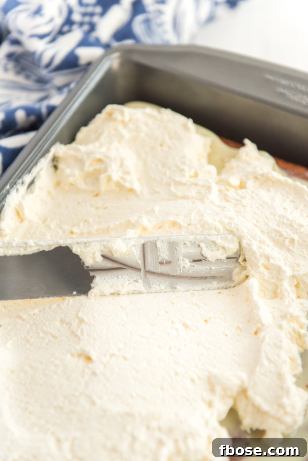Frosting a Caramel Carrot Cake with cheesecake frosting.
