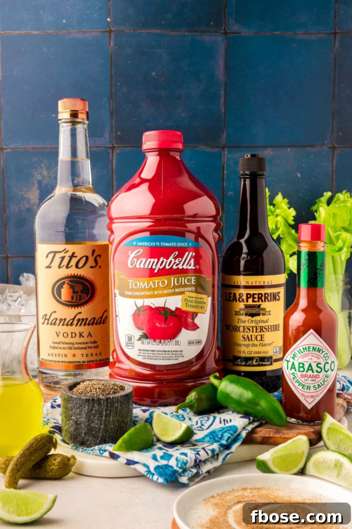 This is the Best Bloody Mary recipe made with vodka, tomato juice, spices, hot sauce, Worcestershire sauce and other delicious ingredients! Perfect for weekend mornings and brunch with friends! A selection of fresh ingredients laid out on a table, ready to be used for crafting the best Bloody Marys, including tomatoes, limes, and spices.