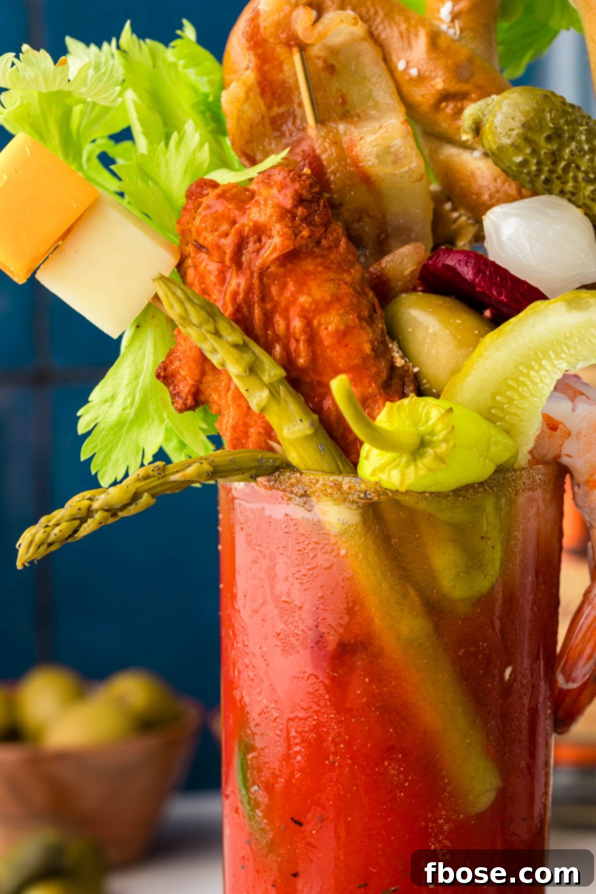 The Ultimate Bloody Mary Recipe 6 Close-up of a glass of Bloody Mary adorned with a variety of fun and savory garnishes, emphasizing the texture and intricate details.