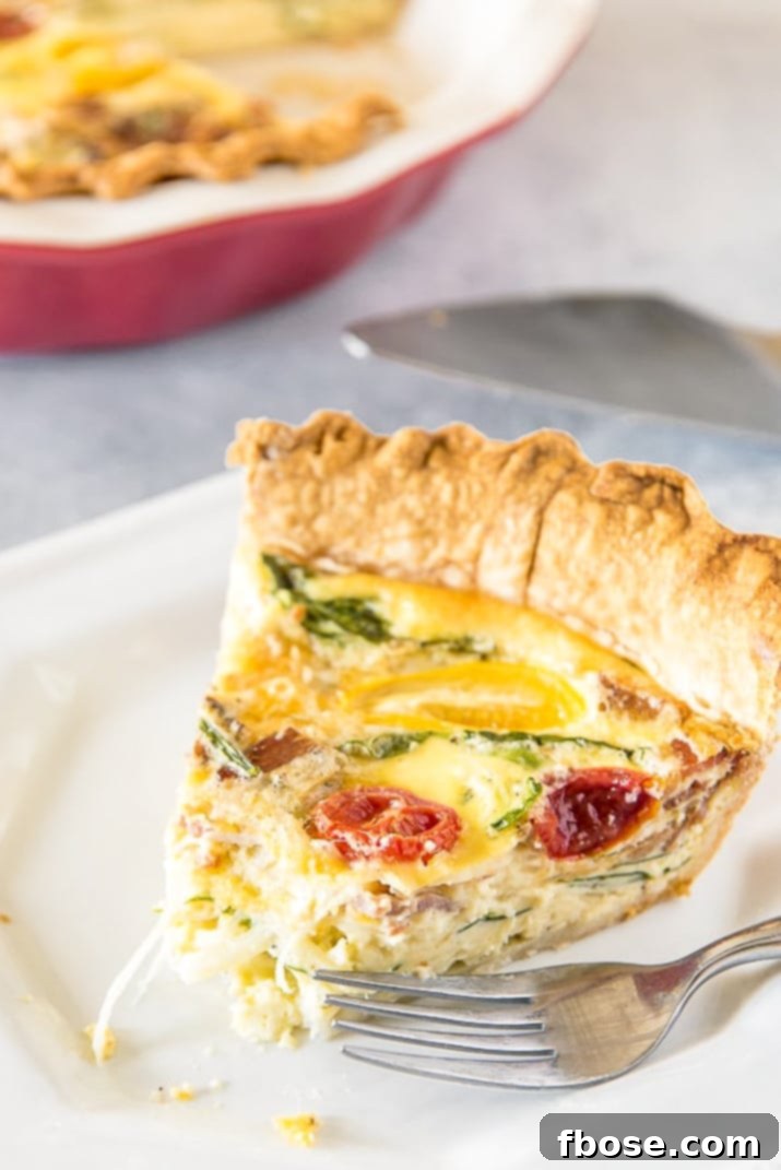 A delectable slice of Quiche Lorraine on a white plate with a bite taken, highlighting its flaky crust and rich filling.