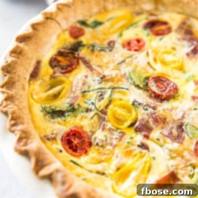 A hearty and crowd-pleasing Bacon Onion Spinach Quiche Lorraine, elegantly simple to prepare.