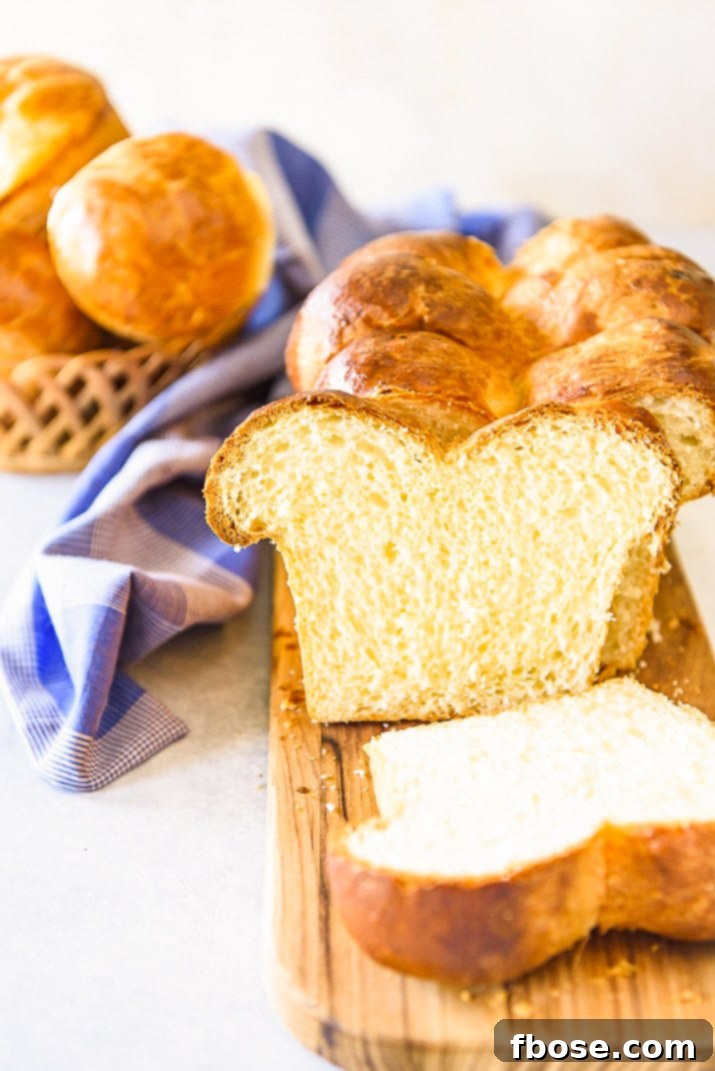 Elegant slices of brioche on a wooden cutting board, accompanied by a folded blue napkin, highlighting the bread's golden hue and soft texture.