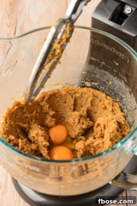The Definitive Chocolate Chip Cookie 12 Two eggs being added to cookie dough.