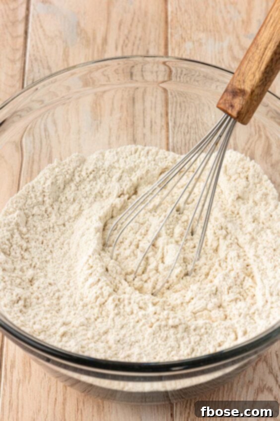 The Definitive Chocolate Chip Cookie 10 Dry ingredients being whisked together in a a mixing bowl.