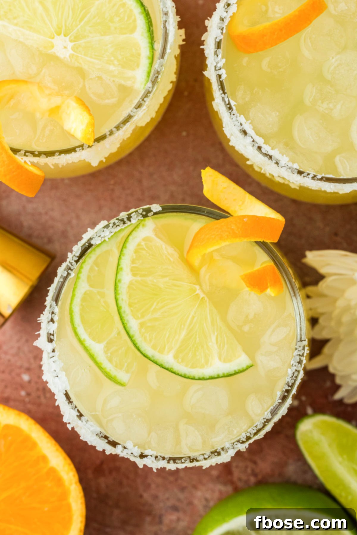 Overhead photo of glasses filled with skinny margaritas and garnished with citrus.