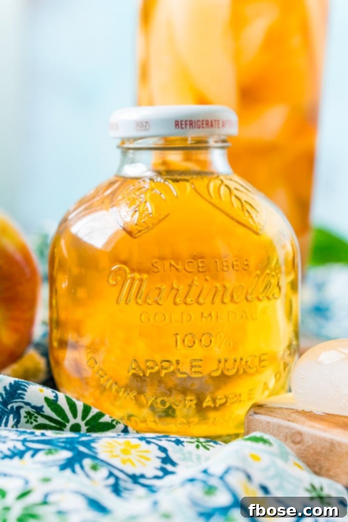 This Homemade Apple Iced Tea is made with freshly brewed black tea, sweet apple juice, fresh apple slices, and a squeeze of lemon for a refreshing summer drink that's easy to make. This flavored iced tea is naturally sweetened by the fruit juice and great for a party! Martinelli's Apple Juice