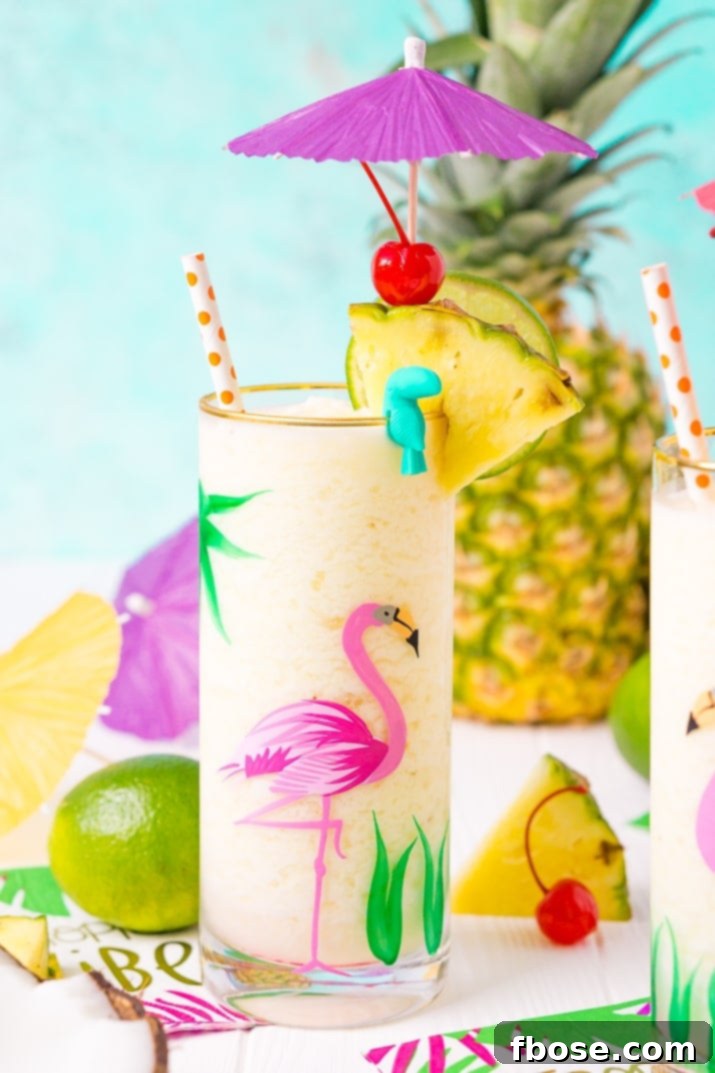 An enticing overhead shot of a perfectly blended Pina Colada in a glass, adorned with a fresh pineapple wedge, a slice of lime, and a maraschino cherry, ready for sipping.