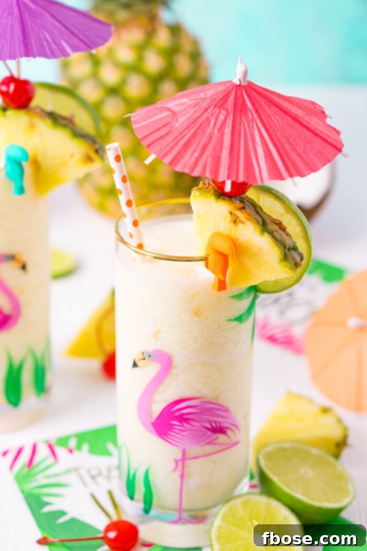 A beautifully composed flat lay showing all the fresh ingredients for a Pina Colada: pineapple chunks, lime, a bottle of Coco Cream, and rum, set against a light background.