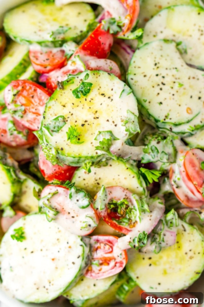 A beautifully presented bowl of Cucumber Tomato Salad on a rustic wooden table, garnished with fresh herbs, showcasing its appetizing appeal and vibrant colors.