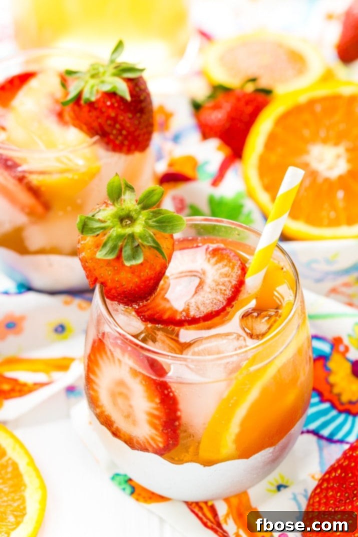 This White Wine Sangria recipe is made with juicy strawberries, oranges, and peaches as well as sweet simple syrup, apricot brandy, and a splash of club soda or seltzer! It's an easy and refreshing summer wine cocktail.