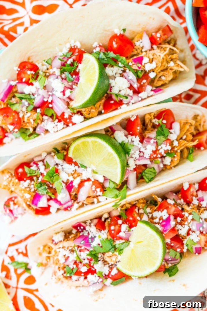 Savory Pulled Chicken Tacos 4 Three shredded chicken tacos garnished with various fresh toppings