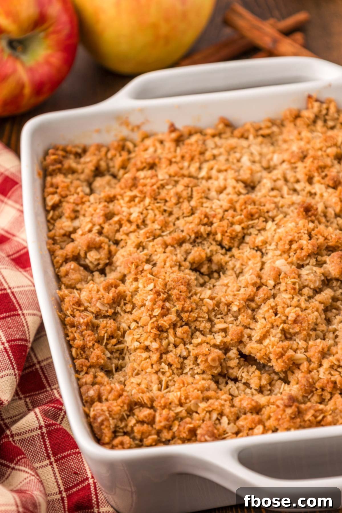 Comforting Apple Oat Crumble 7 Apple Crisp in a white baking dish on a table.