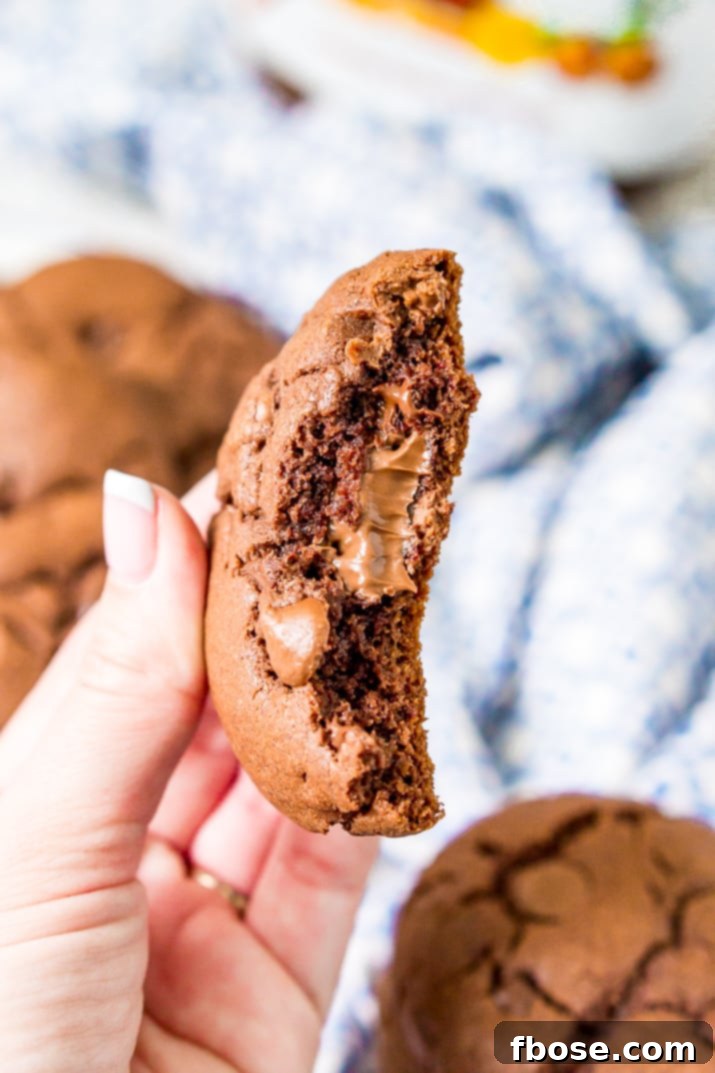 Gooey Nutella Stuffed Cookies 5 A Nutella stuffed cookie broken in half in a woman's hand.