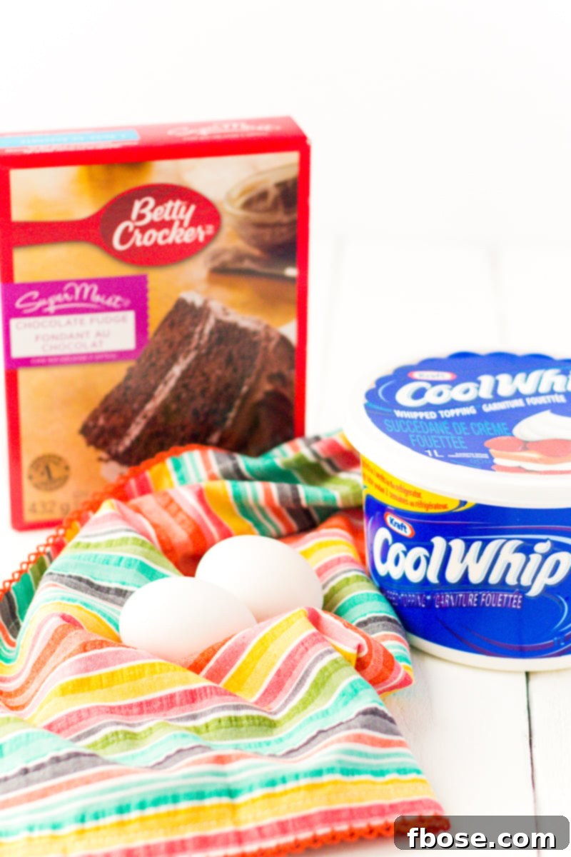 Close-up of freshly baked Cool Whip Cookies dusted with powdered sugar, showcasing their crinkly texture.