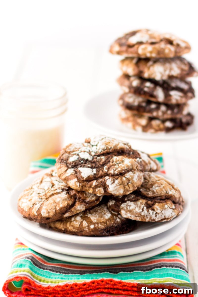 A plate of freshly baked chocolate Cool Whip Cookies, with one broken to show the soft interior.