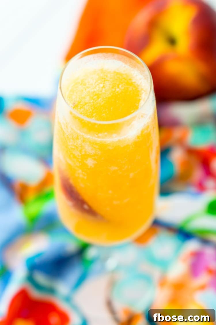A high-speed blender whirling ingredients into a thick, vibrant peach slushie, with fresh peaches and Prosecco bottles visible in the background.
