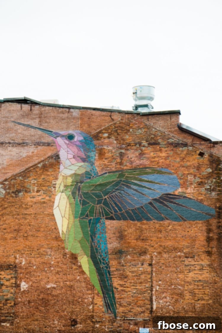 Unlocking Burlington: Essential Experiences in Vermont 3 Vibrant hummingbird mosaic adorning a brick building in Burlington, showcasing the city's lively street art scene.