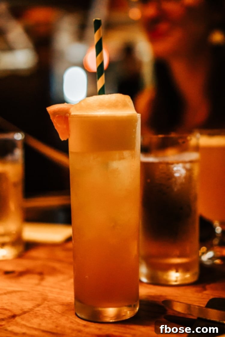 Unlocking Burlington: Essential Experiences in Vermont 6 A refreshing mocktail in a tall glass, garnished with an orange slice, at Hen Of The Wood, reflecting Burlington's vibrant drink scene.