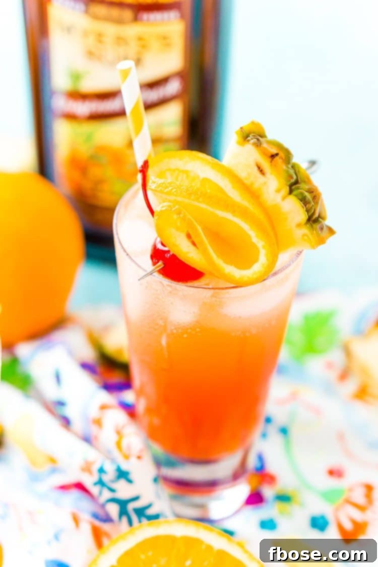Planter's Punch: A Caribbean Classic 5 A close-up of a Planter's Punch glass, artfully garnished with a maraschino cherry, a fresh pineapple wedge, and an orange slice, highlighting its irresistible visual appeal.