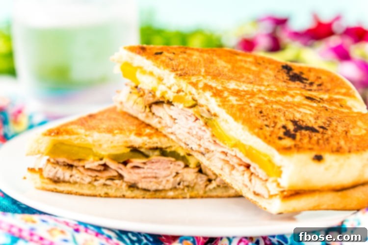 This Cuban Sandwich is loaded with smoked ham, swiss cheese, mojo pork, mustard, and pickles, and then grilled to melty perfection!