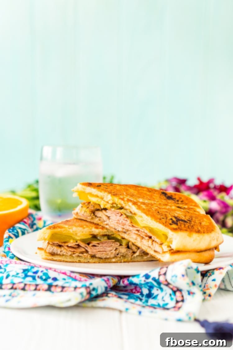 This Cuban Sandwich is loaded with smoked ham, swiss cheese, mojo pork, mustard, and pickles, and then grilled to melty perfection!
