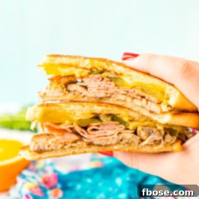 This Cuban Sandwich is loaded with smoked ham, swiss cheese, mojo pork, mustard, and pickles, and then grilled to melty perfection!