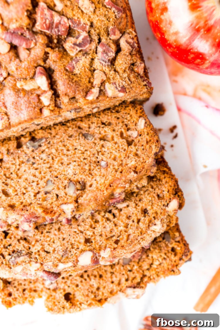 A beautifully sliced loaf of Applesauce Bread, ready to be served, showcasing its golden-brown crust and inviting texture.