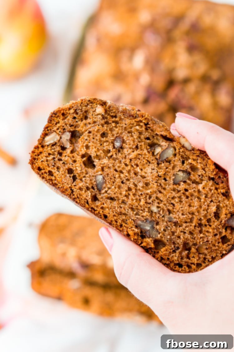 A warm, spiced loaf of Applesauce Bread, ready to be sliced, perfect for cozy gatherings and fall celebrations.
