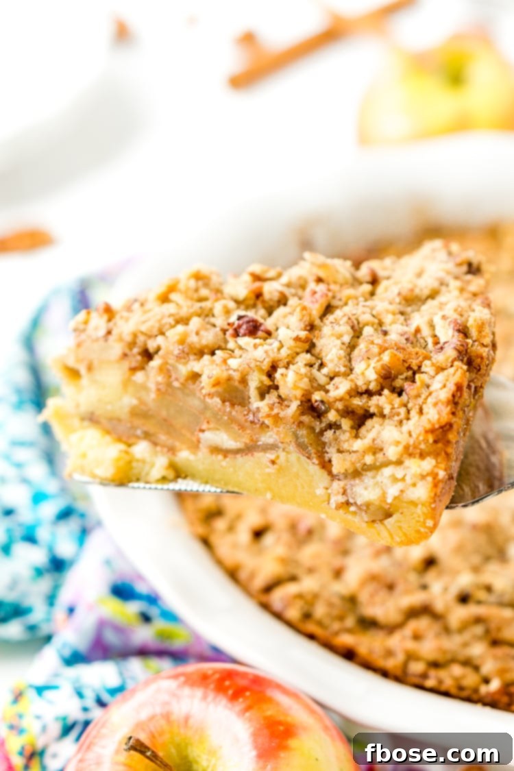 Close-up of a slice of Impossible French Apple Pie, revealing the apple filling and golden crust.