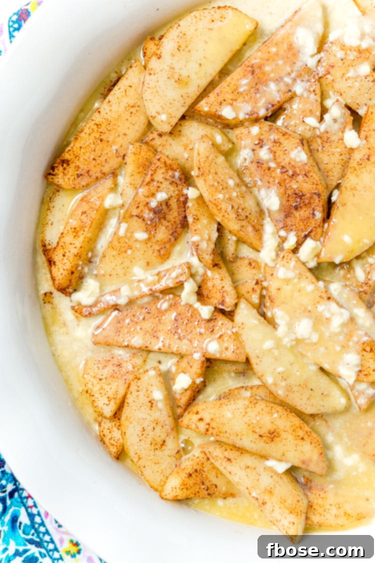 Prepared apple slices in a pie dish, ready for the Bisquick filling.