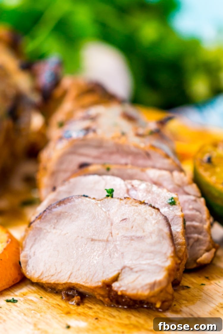 Close-up of raw pork tenderloin marinating in vibrant Cuban Mojo sauce, showcasing the fresh citrus, garlic, and cilantro.