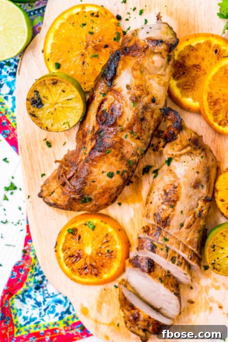 Marinated pork tenderloin slices, glistening with the zesty Cuban Mojo sauce before cooking.