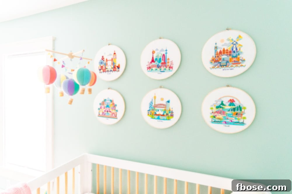 Six exquisite needlepoint circular art pieces, each depicting a different iconic city or destination from around the world, adorning a nursery wall.