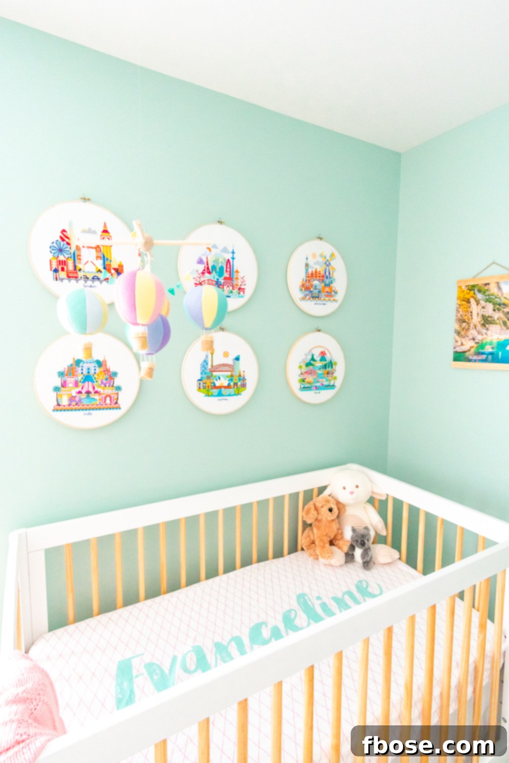 A bright and airy baby girl's travel-themed nursery, featuring a modern crib, global art, and soft textiles.
