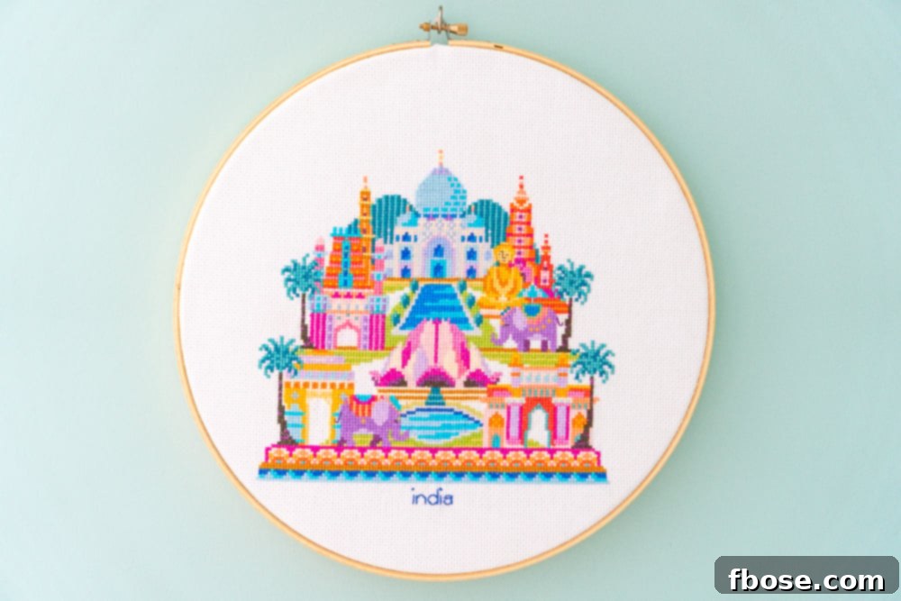 Intricate India cross-stitch hoop art, showcasing cultural symbols like an elephant and traditional patterns, perfect for a global-themed nursery.
