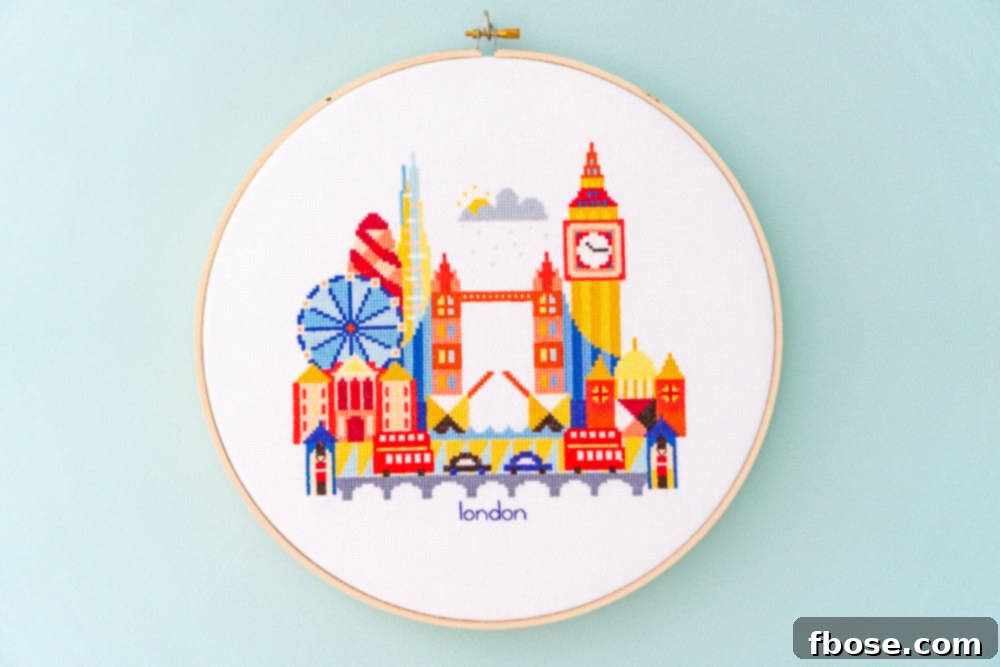 Classic London cross-stitch hoop art, showcasing Big Ben and a red double-decker bus, perfect for a distinctly British nursery accent.