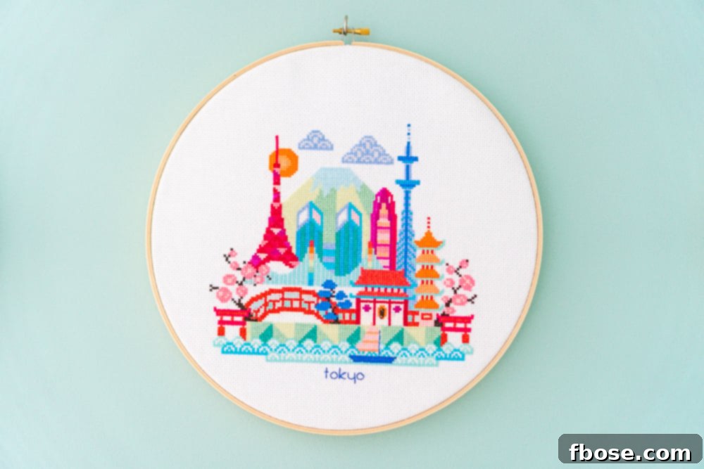 Modern Tokyo cross-stitch hoop art, depicting futuristic skylines and cherry blossoms, a stylish addition to a global-inspired nursery.