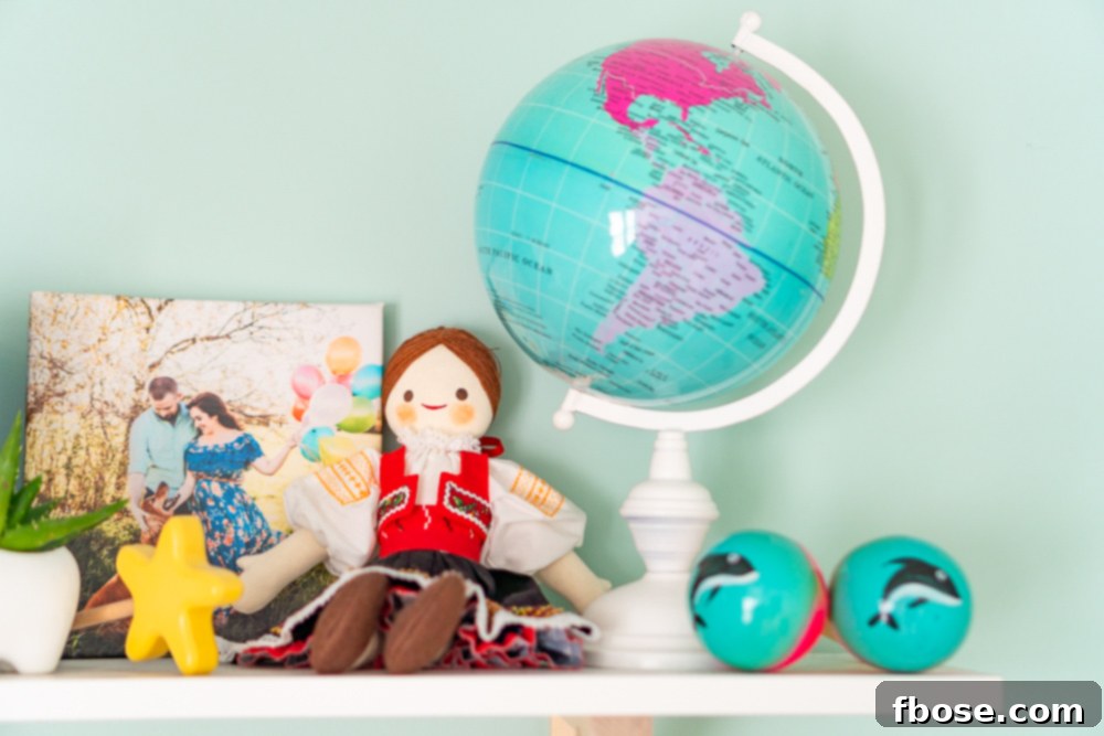 A close-up of a shelf in a baby nursery adorned with travel-inspired decor, including a globe, doll, and various global trinkets.