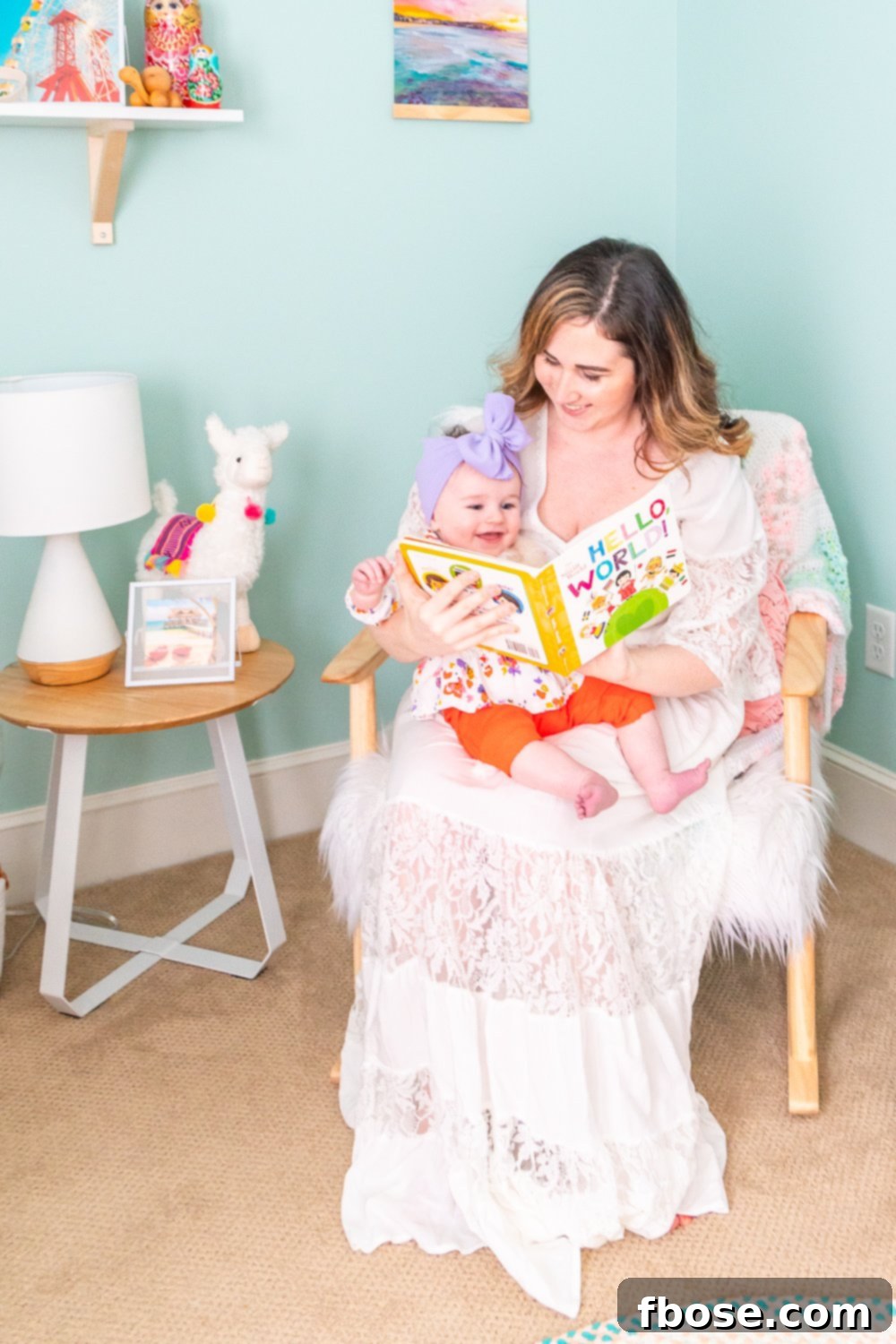 A loving mother reads a book to her baby daughter while comfortably seated in a rocking chair within their beautiful nursery.