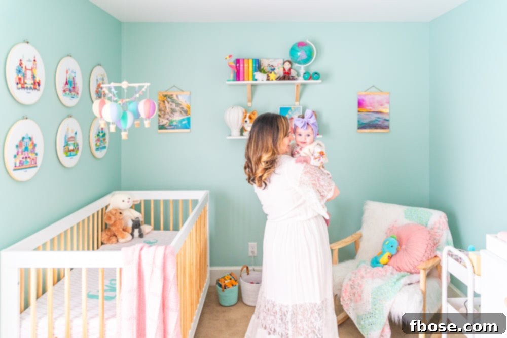A loving mother cradles her baby girl in a beautifully decorated travel-inspired nursery, featuring a white crib and unique decor.